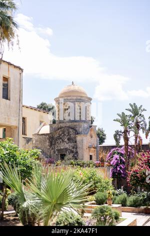 Uno scatto verticale dell'antico monastero di Agia Triada in Grecia circondato da una vegetazione colorata Foto Stock