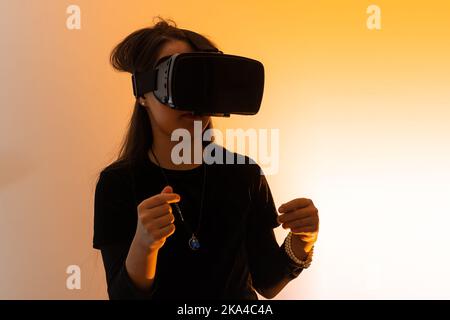 una bambina stupita indossa occhiali vr utilizzando la tecnologia per l'istruzione nella realtà virtuale, nel mondo virtuale. Banner di bambina con realtà virtuale vr Foto Stock