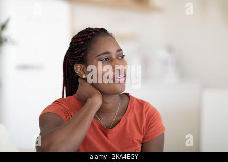 Primo piano Ritratto della giovane donna afro-americana sognante che si rilassa a casa Foto Stock