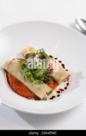 Cannelloni con ricotta e spinaci serviti con rucola, radicchio e vinager balsamico Foto Stock