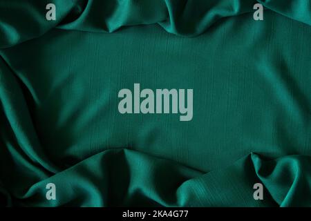 Astratto lino misto tessuto sfondo ondulato struttura. Crumpled verde scuro tinta tinto biancheria tessile sfondo tela. Vista dall'alto Foto Stock