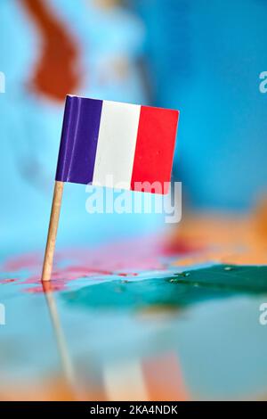 Primo piano di una bandiera francese con un piccolo bastone sulla mappa Foto Stock