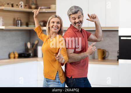 Gioiosa uomo e donna di mezza età che si divertono a casa Foto Stock