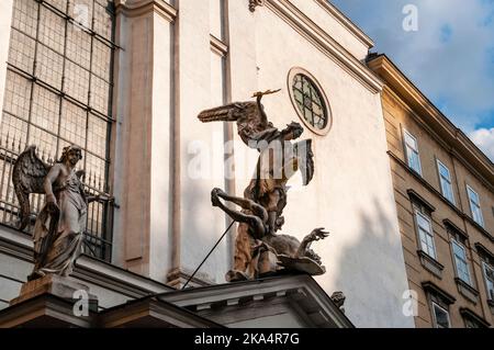 L'Arcangelo Michele uccide Lucifero sull'ingresso fronteggiante della Chiesa di San Michele nel centro di Vienna, Austria. Foto Stock