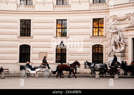 Le carrozze viennesi trainate da due cavalli fanno parte del paesaggio della capitale austriaca. Foto Stock