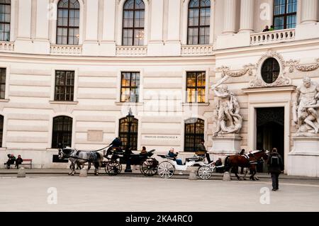 Le carrozze viennesi trainate da due cavalli fanno parte del paesaggio della capitale austriaca. Foto Stock