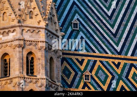 Tetto in tegole multicolore e torre romanica nella Cattedrale di Santo Stefano a Vienna, Austria. Foto Stock