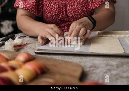Giovani donne che fanno pasticceria con le mele Foto Stock