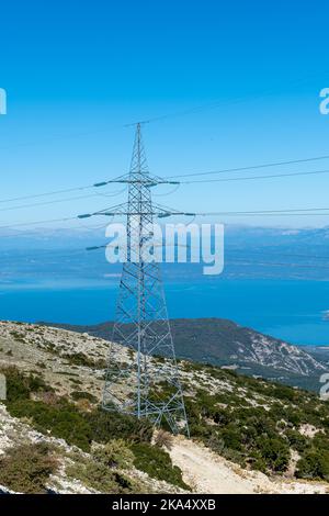 Una torre di trasmissione dell'elettricità o un pilone in cima alla montagna. Foto Stock