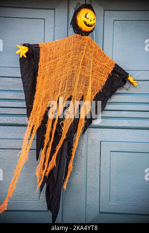 Un tipo di mostro fantasma di zucca. Una decorazione di Halloween appesa alla porta del garage di qualcuno. Foto Stock