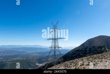 Una torre di trasmissione dell'elettricità o un pilone in cima alla montagna. Foto Stock