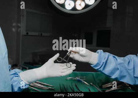 Primo piano chirurghi prendere le forbici a mano Foto Stock