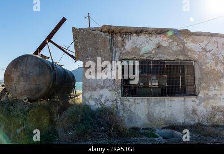 La casa in decadenza e il serbatoio di stoccaggio di un edificio industriale abbandonato. Foto Stock