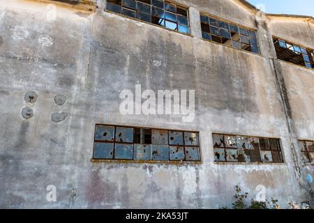 Le finestre rotte di un edificio di fabbrica derelitto. Foto Stock