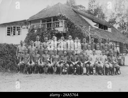 Guerra del Pacifico, 1941-1945. Il cadre dell'Esercito imperiale giapponese 230th Reggimento della fanteria fotografato a Sumatra, nelle Indie Orientali olandesi, 1942. Al centro della prima fila c'è il comandante del reggimento, il colonnello Shoji. Cresciuto a Shizuoka alla fine degli anni '30, il reggimento della fanteria del 230th vide la sua prima azione in Cina. Con lo scoppio della guerra del Pacifico nel dicembre del 1941 il reggimento partecipò alla battaglia di Hong Kong, seguita dall'invasione delle Indie Orientali olandesi, e successivamente alla Campagna di Guadalcanal, dove avrebbero subito pesanti perdite prima di ritirarsi dall'isola. Foto Stock