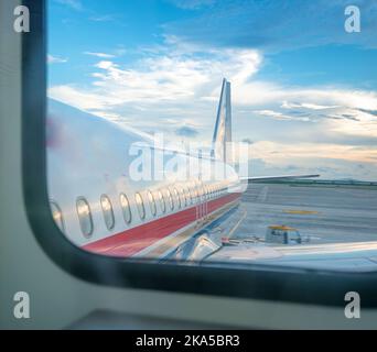 Finestre e fusoliera di un aereo privato con coda contro il cielo nuvoloso Foto Stock