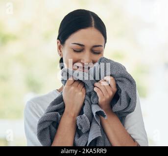 Lavanderia, fresco e donna che odora vestiti puliti con un sorriso, pace e calma in una casa. Felice, giovane e sorridente pulizia vestiti, biancheria e. Foto Stock