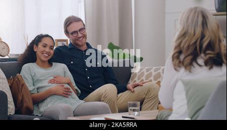 Felice, consigliante e coppia con uno psicologo in un ufficio per una sessione di terapia insieme. Felicità, donna incinta e suo marito che parla con un Foto Stock