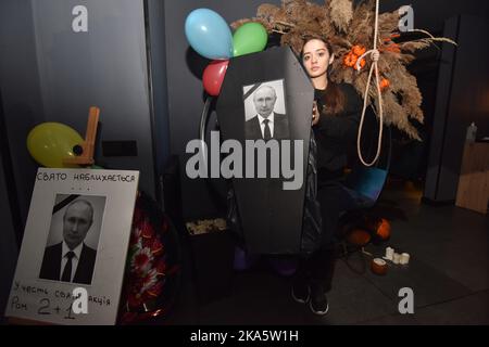 Lviv, Ucraina. 31st Ott 2022. Una ragazza tiene una bara con un ritratto del presidente russo Vladimir Putin durante la celebrazione di Halloween in uno dei bar di Lviv Credit: SOPA Images Limited/Alamy Live News Foto Stock