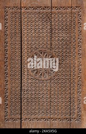 Particolare della vecchia porta di madrasa in legno con intricato e tradizionale design islamico geometrico e floreale con motivi solari, Hisor, Tagikistan Foto Stock