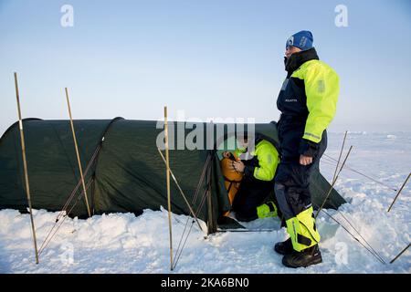 Vicino al Polo Nord 20150422. Il principe ereditario Haakon disimballando i loro sacchi a pelo, mentre la principessa ereditaria mette-Marit aspetta fuori. La coppia reale sta visitando la nave di ricerca norvegese 'Lance' situata a 83 gradi a nord dell'Oceano Artico. Chiesero se potevano dormire in una tenda sul ghiaccio. Foto: Tore Meeke / NTB scanpix Foto Stock