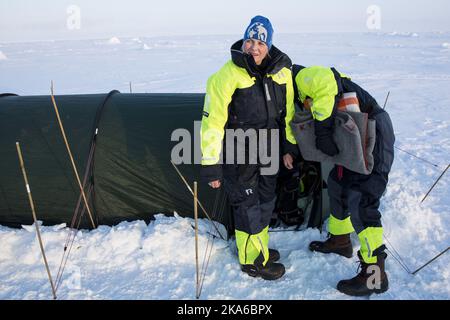 Vicino al Polo Nord 20150422. Il principe ereditario Haakon disimballando i loro sacchi a pelo, mentre la principessa ereditaria mette-Marit aspetta fuori. La coppia reale sta visitando la nave di ricerca norvegese 'Lance' situata a 83 gradi a nord dell'Oceano Artico. Chiesero se potevano dormire in una tenda sul ghiaccio. Foto: Tore Meeke / NTB scanpix Foto Stock