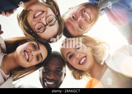 Siamo insieme e questo è ciò che rende un successo. Colleghi guardando giù la fotocamera. Foto Stock