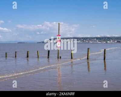 La spiaggia di Uphill durante l'alta marea con Weston-super-Mare Beyond, North Somerset, Inghilterra. Foto Stock