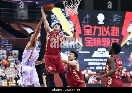 (200707) -- QINGDAO, 7 luglio 2020 (Xinhua) -- Jiang Yuxing (2nd L) di Jilin Tigers Nordest vies con Fan Ziming di Xinjiang Flying Tigers durante una partita alla lega 2019-2020 della Associazione Cinese di Pallacanestro (CBA) a Qingdao, provincia di Shandong nella Cina Orientale, 7 luglio 2020. (Xinhua/Guo Xulei) Foto Stock