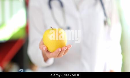 Medico che tiene in mano mela gialla matura Foto Stock