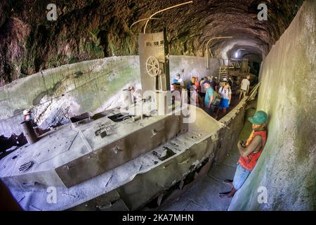 I turisti che visitano i resti del trasporto giapponese della seconda guerra mondiale chiatta nel tunnel chiatta. Rabual, Isola della Nuova Gran Bretagna, Papua Nuova Guinea Foto Stock