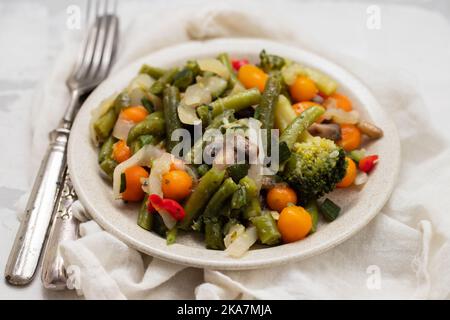 Verdure bollite miste su un piatto marrone chiaro Foto Stock