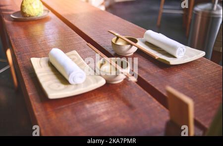Ristorante giapponese in stile tradizionale, piatto vuoto sul tappeto vicino al piatto del bastone, fuoco selettivo Foto Stock