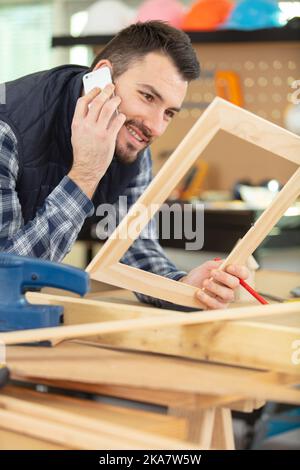 uomo che tiene la cornice e il telefono Foto Stock