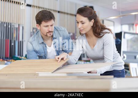 L uomo e la donna la scelta di materiale per mobili da cucina in salone Foto Stock