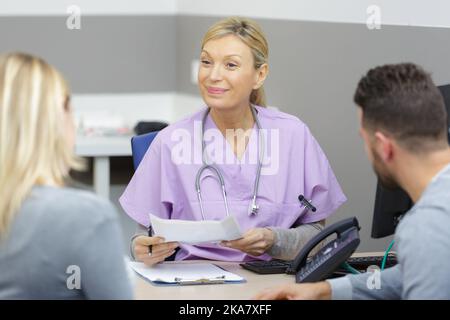 coppia sorridente con il loro medico Foto Stock