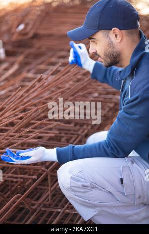 un costruttore lavora alla costruzione di strutture in cemento Foto Stock