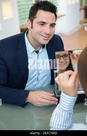 Uomo cerca su nuovi occhiali a ottici Foto Stock