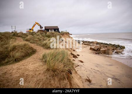 Dunes Cafe Demolition, Winteron-on-Sea, Norfolk, 4th dicembre 2020 Un caffè sulla costa Norfolk è stato demolito oggi dopo alte maree finalmente eroso la spiaggia di Winterton-on-Sea vicino GT Yarmouth, dove i proprietari di terra avevano trascorso molti anni e 10's di migliaia di sterline cercando di fermare l'erosione. Il caffè Dunes, popolare tra gli escursionisti costieri e gli osservatori di foche è stato aperto nei primi anni '70 Fotografia di Jason Bye t: 07966 173 930 e: mail@jasonbye.com w: www.jasonbye.com Foto Stock