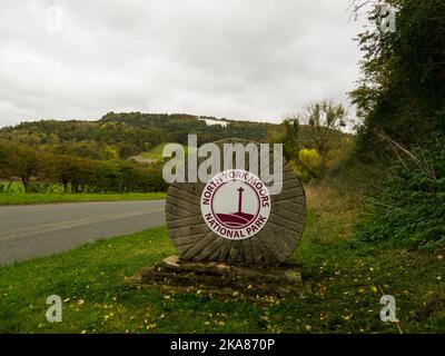 Pietra del mulino che mostra l'ingresso al Parco Nazionale di North Yor Moors con il Whire Horse of Kilburn in lontananza intagliato in una zona boscosa dello Yorkshire Inghilterra Regno Unito Foto Stock