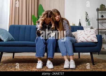 La figlia adulta abbraccia la madre sconvolta. Giovane donna che abbraccia di infelice mommia di mezza età stressata, confortandola a casa Foto Stock