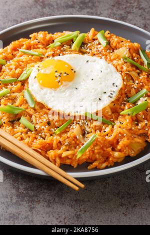 Kimchi riso fritto Bokkeumbap è un tipo di cibo coreano closeup sul piatto sul tavolo. Verticale Foto Stock