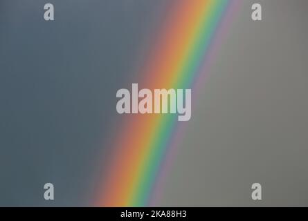 Parte di un arcobaleno su un cielo nuvoloso, una tempesta, una luce Foto Stock