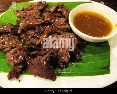 Salsa marinata di carne di manzo con sesamo fritto profondo e bianco servire con salsa piccante e verdure di contorno per i clienti thailandesi mangiare e bere Foto Stock
