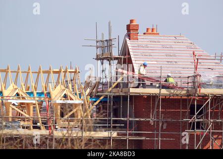 Operai di costruzione. Costruttori di impalcature erigere una nuova casa di costruzione. Foto Stock