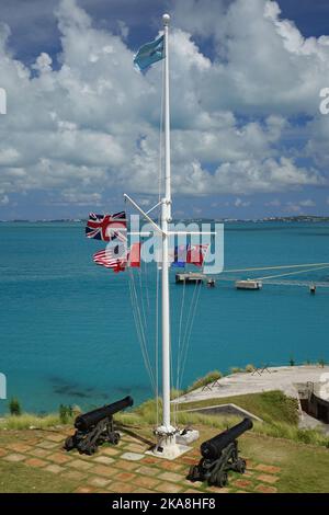 Una vista a volo d'uccello di due vecchi cannoni e di un palo di metallo con bandiere svolazzanti presso il Museo Nazionale delle Bermuda, Ireland Island, Sandys Parish Foto Stock