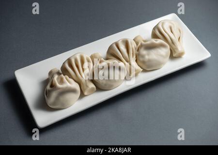 gnocchi di khinkali georgiani tradizionali con formaggio o carne su sfondo grigio Foto Stock