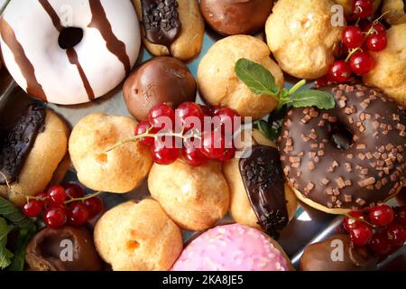 Una vista dall'alto di diverse ciambelle e dolci con alcune ciliegie Foto Stock