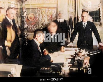 Benito Mussolini e il primo Ministro francese Pierre Laval firmano a Roma un accordo franco-italiano. 1935 - Signature a Rome des accords franco-italiens le 7 janvier 1935 laissant les italiens libres d'agir en Abyssinie : ici Pierre Laval, president du conseil assis au bureau, et Benito Mussolini Foto Stock