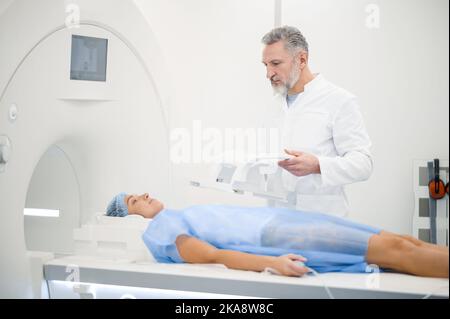 Medico che lavora nel centro diagnostico e che guarda coinvolto Foto Stock